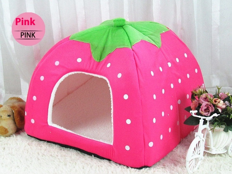 Pink strawberry-shaped pet bed with white polka dots on a light background