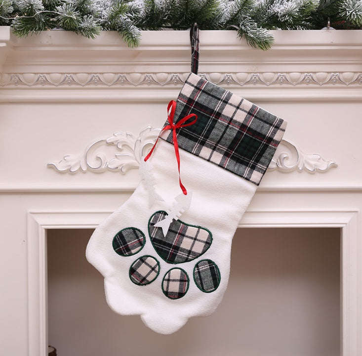 White paw-shaped Christmas stocking with dark green plaid cuff, matching paw pads, and red ribbon
