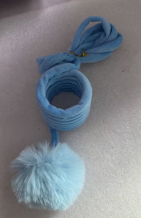 Blue hair tie with a pom-pom on a light gray background