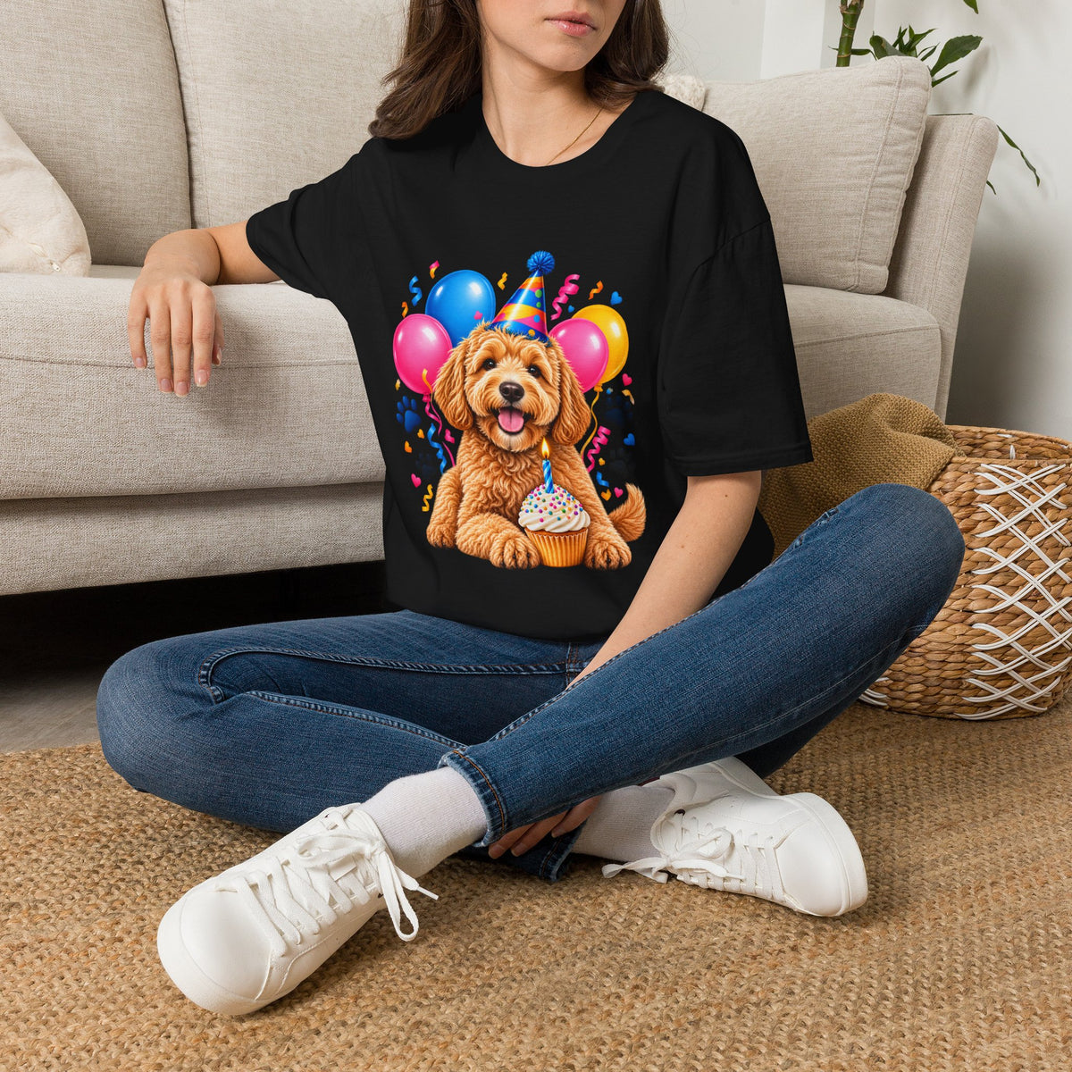 Woman sitting on floor wearing a Black Birthday Dog T-Shirt with colorful puppy birthday party design