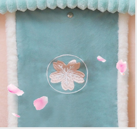 Light blue fabric with a pink floral embroidery design and pink petals on a white background