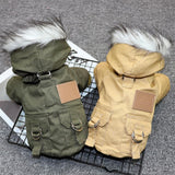 Two dog coats, one green and one beige, on a wire rack with a textured gray background.