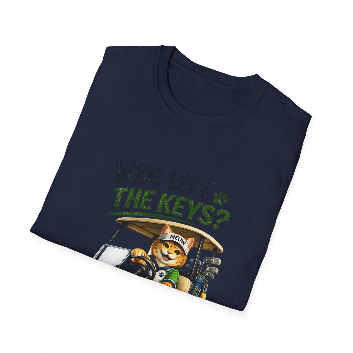 A navy blue folded t-shirt with a graphic print of an orange tabby cat driving a golf cart. The text 'WHO LEFT THE KEYS?' is printed above the cat in green and gray.