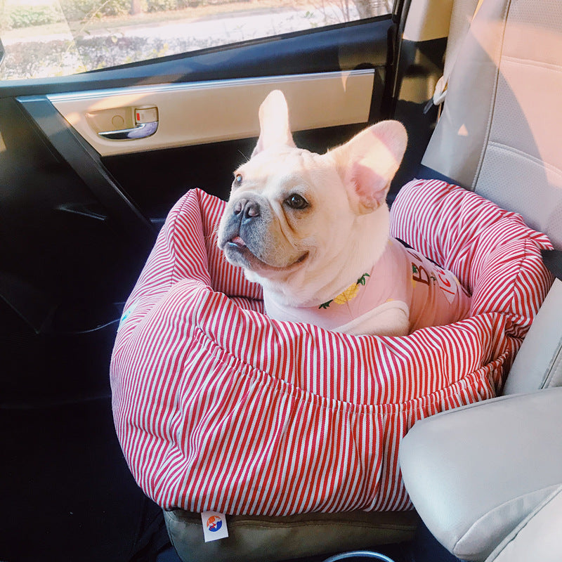 Dog in a red and white striped pet seat cover inside a car