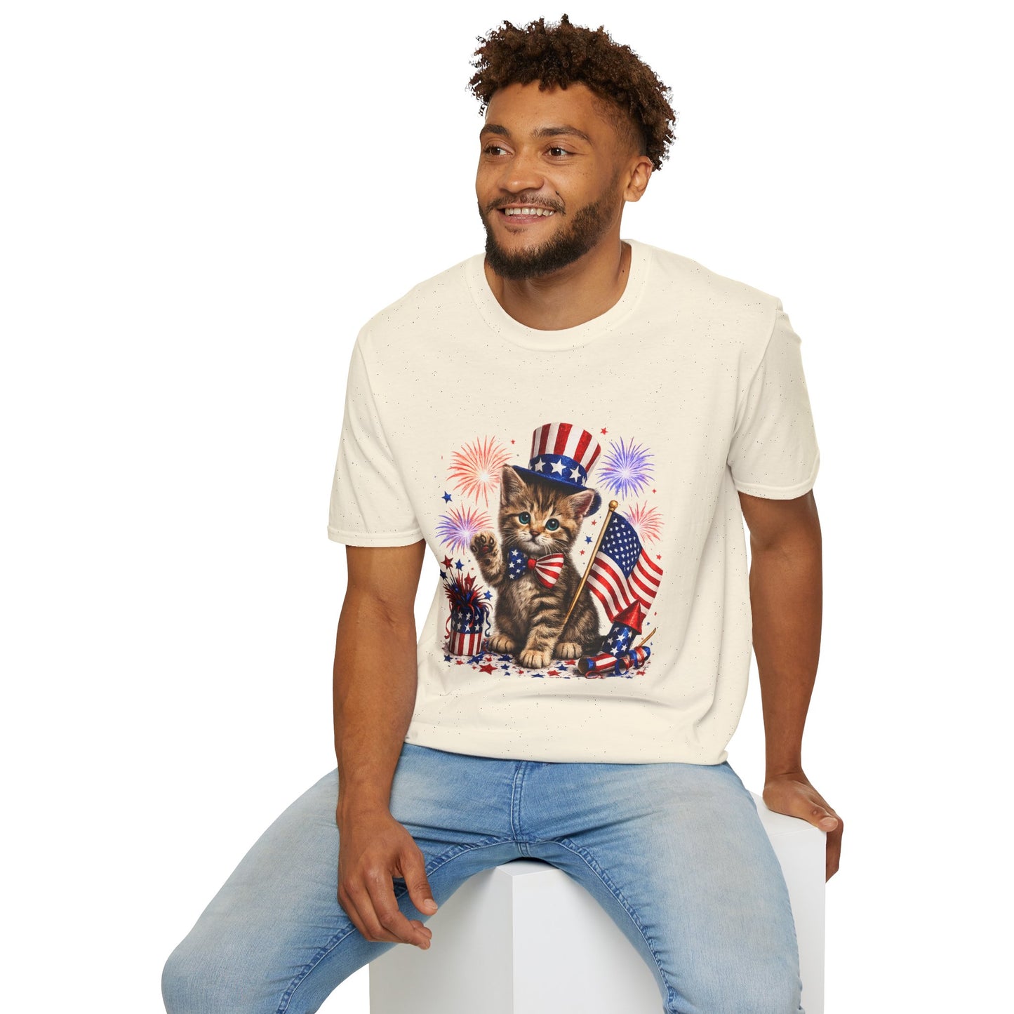 Man wearing a cream t-shirt with a kitten in a hat and American flag graphic.