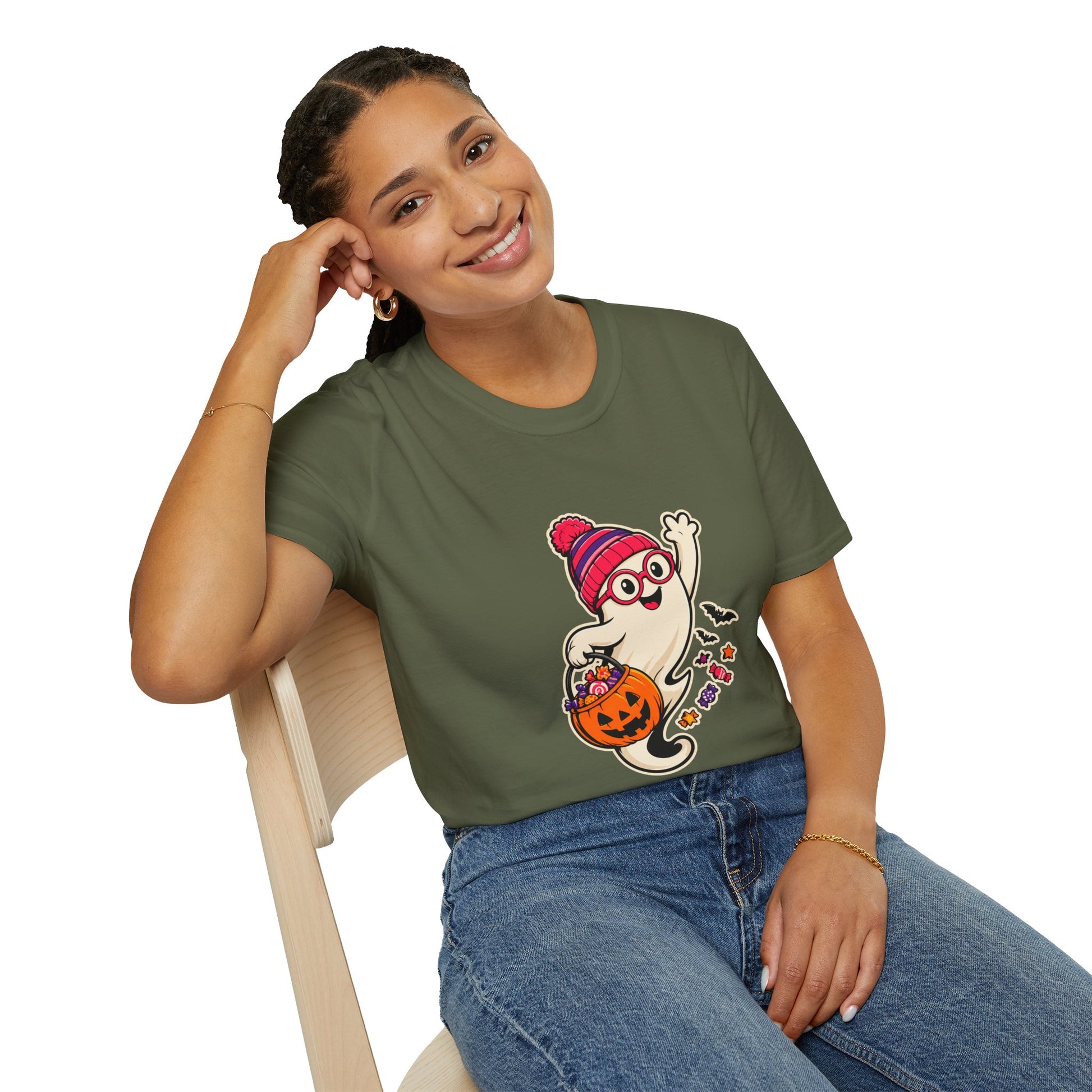 A military green short-sleeve crewneck t-shirt featuring a cartoon graphic of a cute ghost wearing a pink and red striped knit hat and glasses, holding a jack-o'-lantern bucket filled with candy.