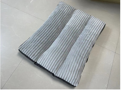 Folded gray and white pleated mat on a tiled floor