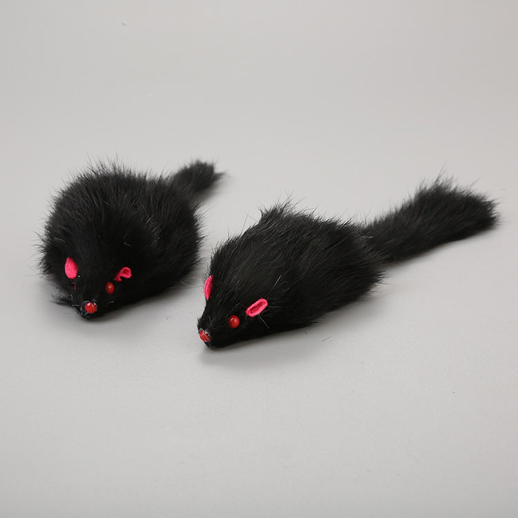 Two black furry mouse toys with red eyes on a gray background