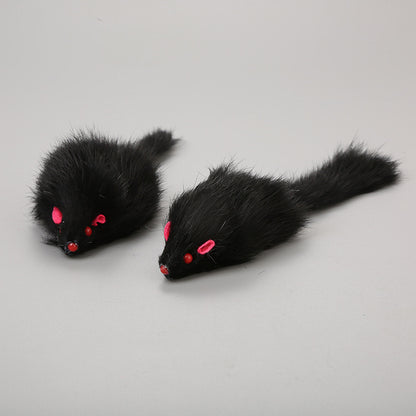 Two black furry mouse toys with red eyes on a gray background