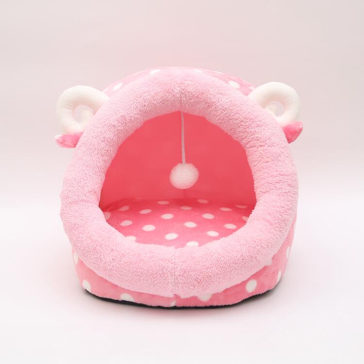 Pink pet bed with polka dot interior on a white background