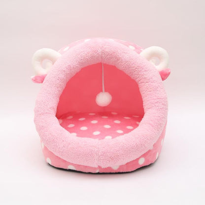 Pink pet bed with polka dot interior on a white background