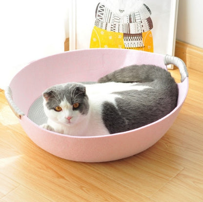 Cat lying in a pink pet bed on a wooden floor