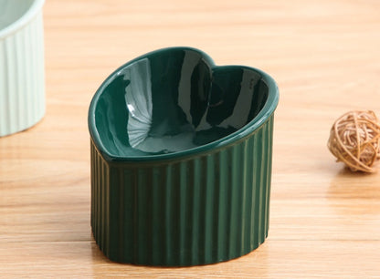 Green heart-shaped bowl on a wooden surface