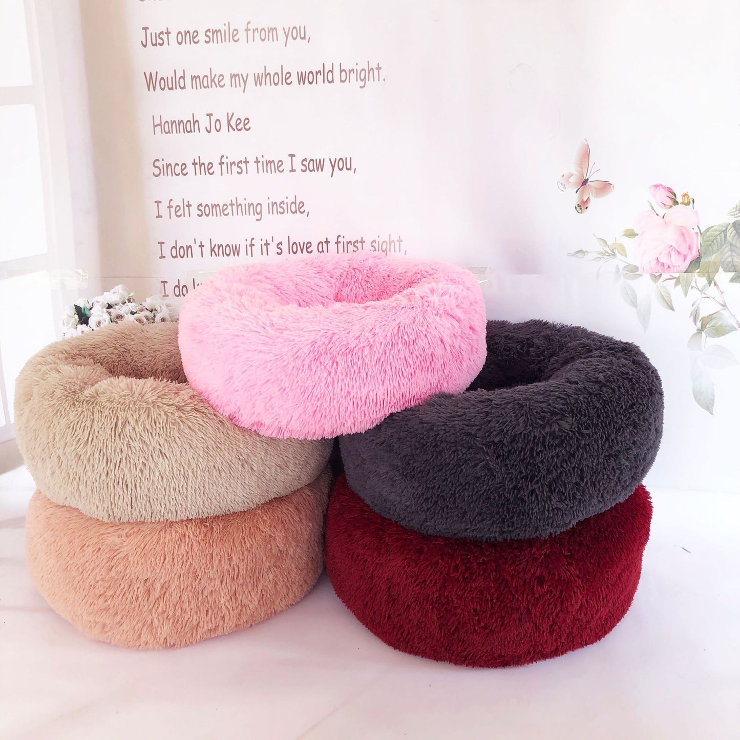 Four plush donut cushions in different colors with a quote in the background.