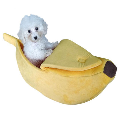 Dog lying inside a banana-shaped pet bed on a white background