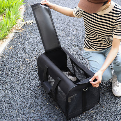 Person opening a black pet carrier on a paved surface