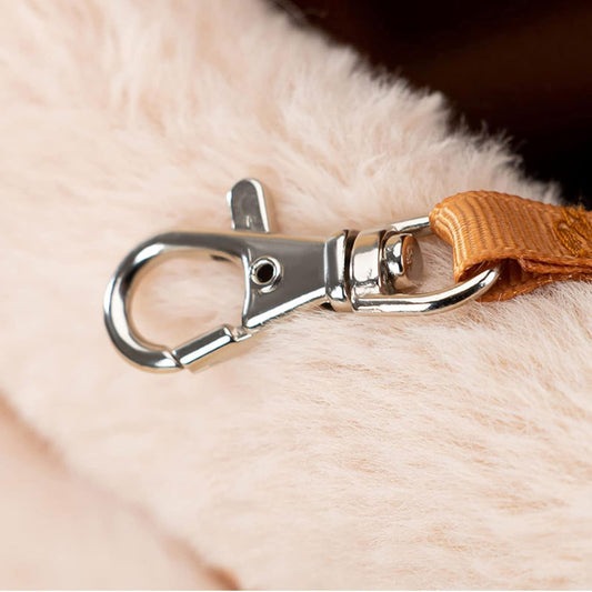 Close-up of a metal clasp on a brown leather strap against a fur background