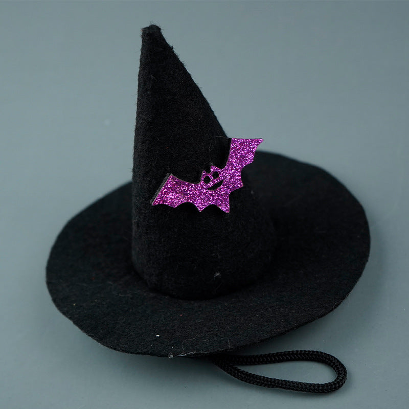 Black witch hat with a purple bat decoration on a gray background