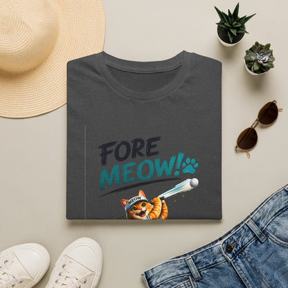 A folded dark charcoal gray t-shirt with a graphic print reading 'FORE MEOW!' in teal and black, featuring an orange tabby cat holding a toy laser pointer. The shirt is styled in a flat lay with a straw hat, white sneakers, blue jeans, and small potted succulents on a light beige background.