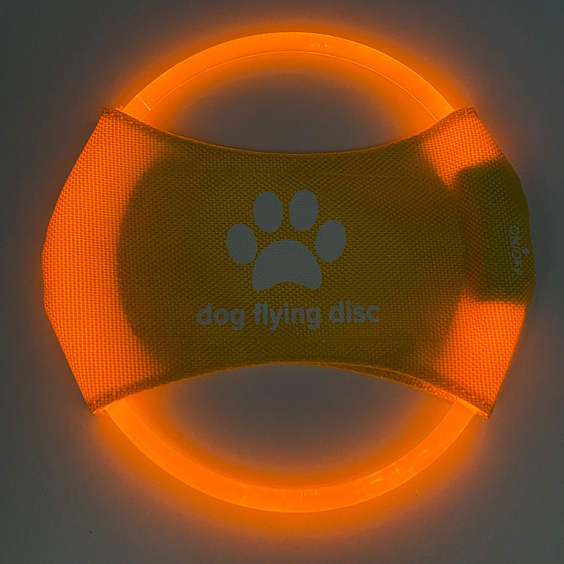 Orange dog flying disc with a paw print and text on a dark background