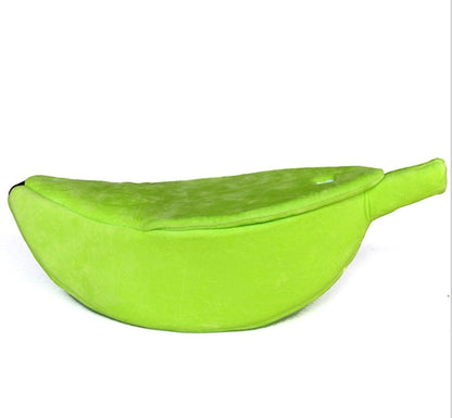 Green banana-shaped dog bed on a white background