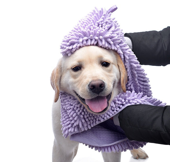 Dog wrapped in a purple towel with a white background