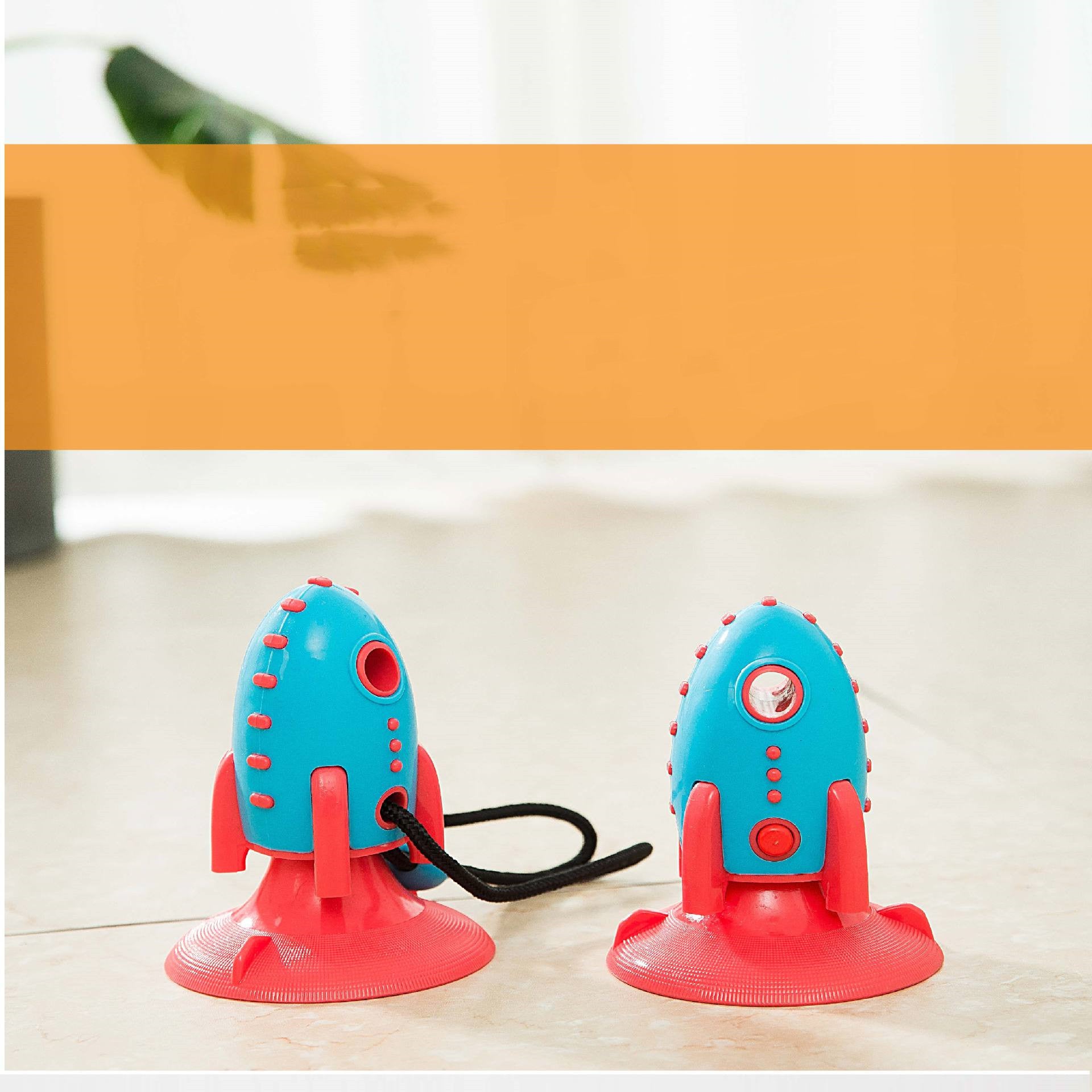 Two blue and red suction cup toys on a white surface with an orange banner above.