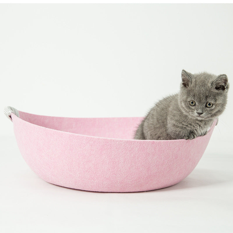 Gray kitten in a pink pet bed on a white background