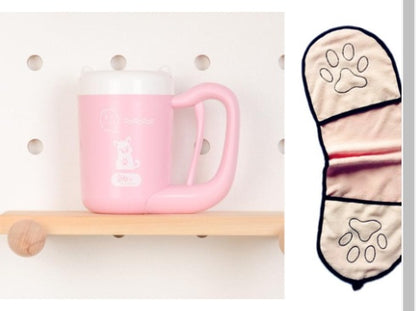 Pink mug with white paw print design on a wooden shelf, next to a matching oven mitt with paw prints.