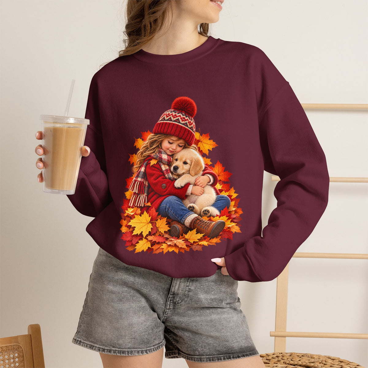 Woman holding a drink maroon wearing the white Golden Moments girl and puppy fall sweatshirt