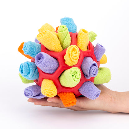 Colorful textured ball toy held in a hand against a white background
