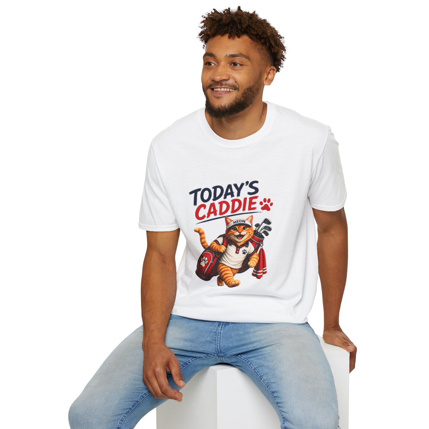 An white short-sleeve crewneck t-shirt featuring a cartoon graphic of an orange tabby cat wearing a cap and holding golf clubs, with the text 'TODAY'S CADDIE' 