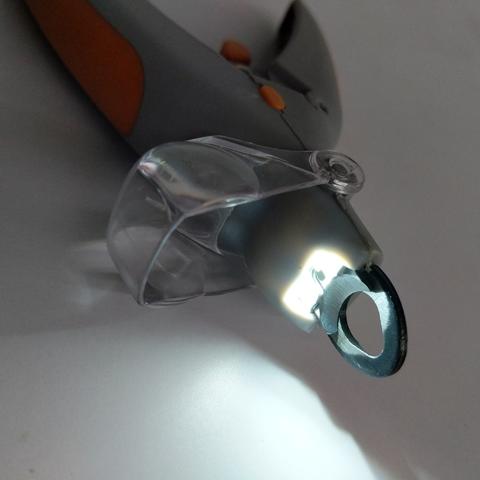 Close-up of a tool with a clear plastic component on a gray background