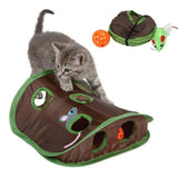 Cat playing with a brown and green cat toy shaped like a snake, with a small orange ball and green mouse toy.
