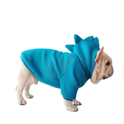 Dog wearing a blue dinosaur costume on a white background