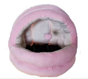 Pink pet bed with a small animal peeking out on a white background