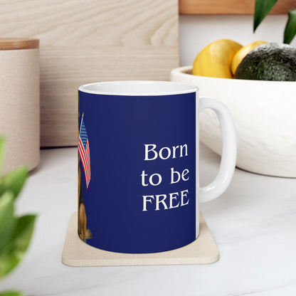 Mug with 'Born to be FREE' text on a blue background, placed on a white surface with a plant and container in the background.