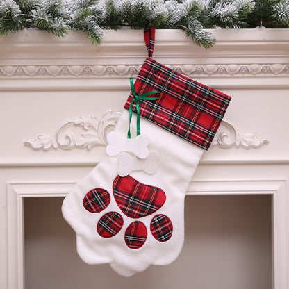 White paw-shaped Christmas stocking with red plaid cuff, matching paw pads, and green ribbon