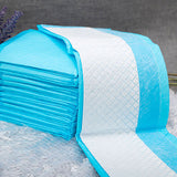 Stack of blue and white quilted mattress toppers on a textured surface.