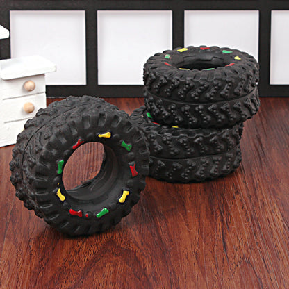 Black textured dog toys with colorful accents on a wooden surface