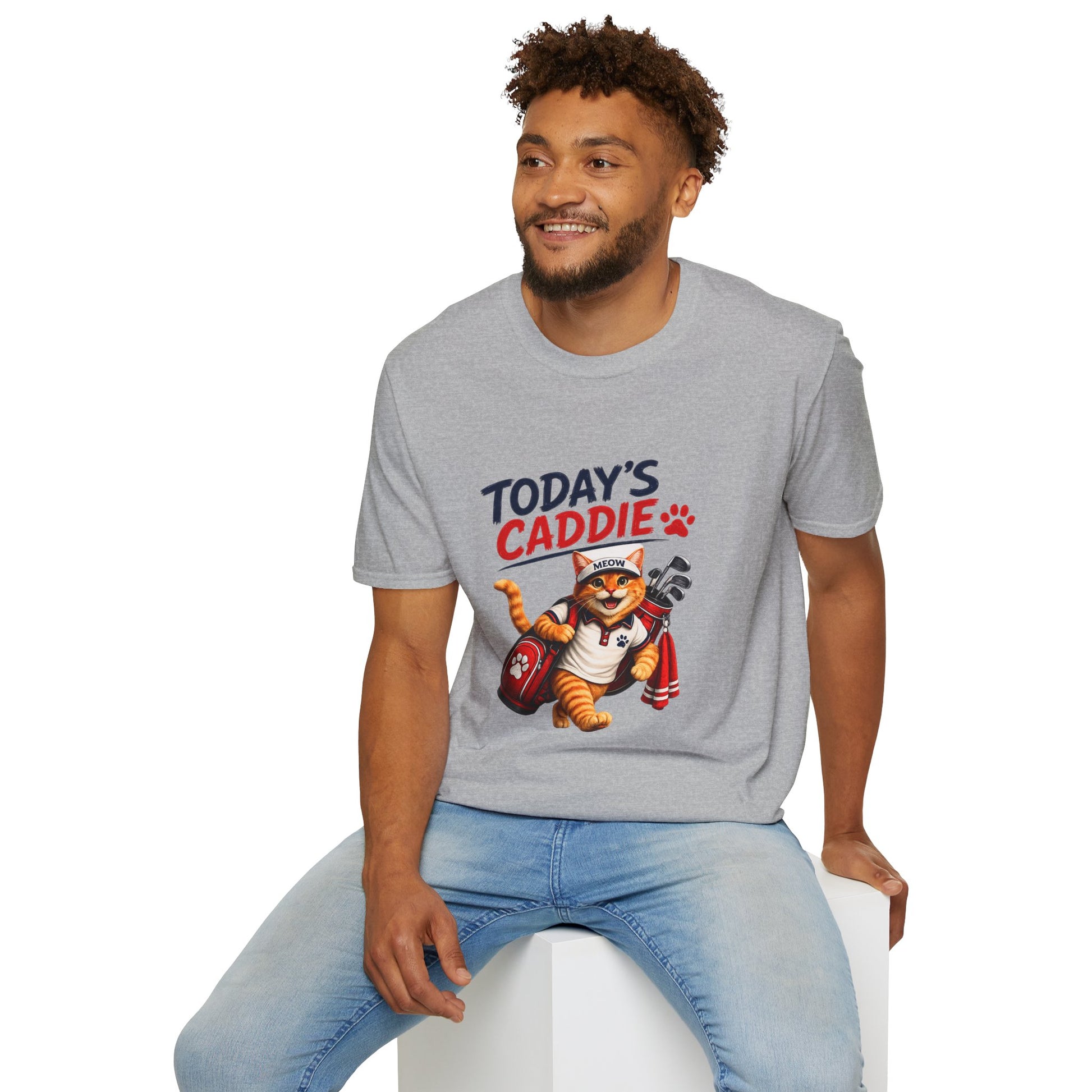 An sport grey short-sleeve crewneck t-shirt featuring a cartoon graphic of an orange tabby cat wearing a cap and holding golf clubs, with the text 'TODAY'S CADDIE' 