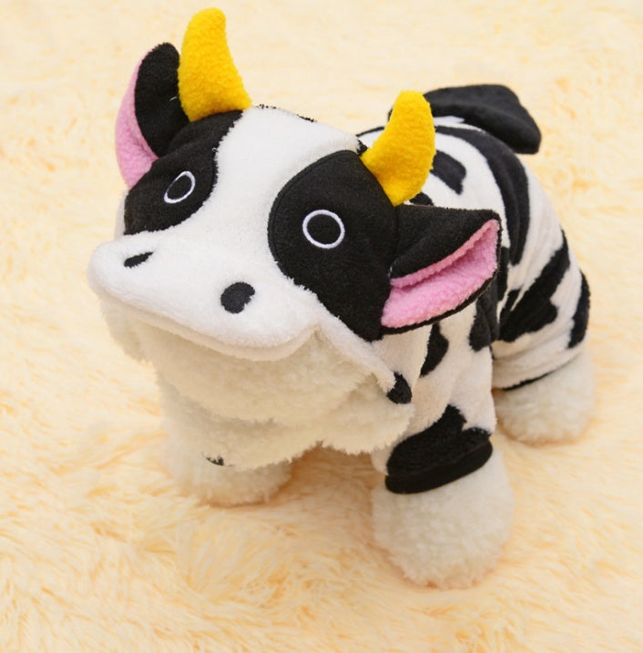 Plush toy cow with yellow horns on a beige background