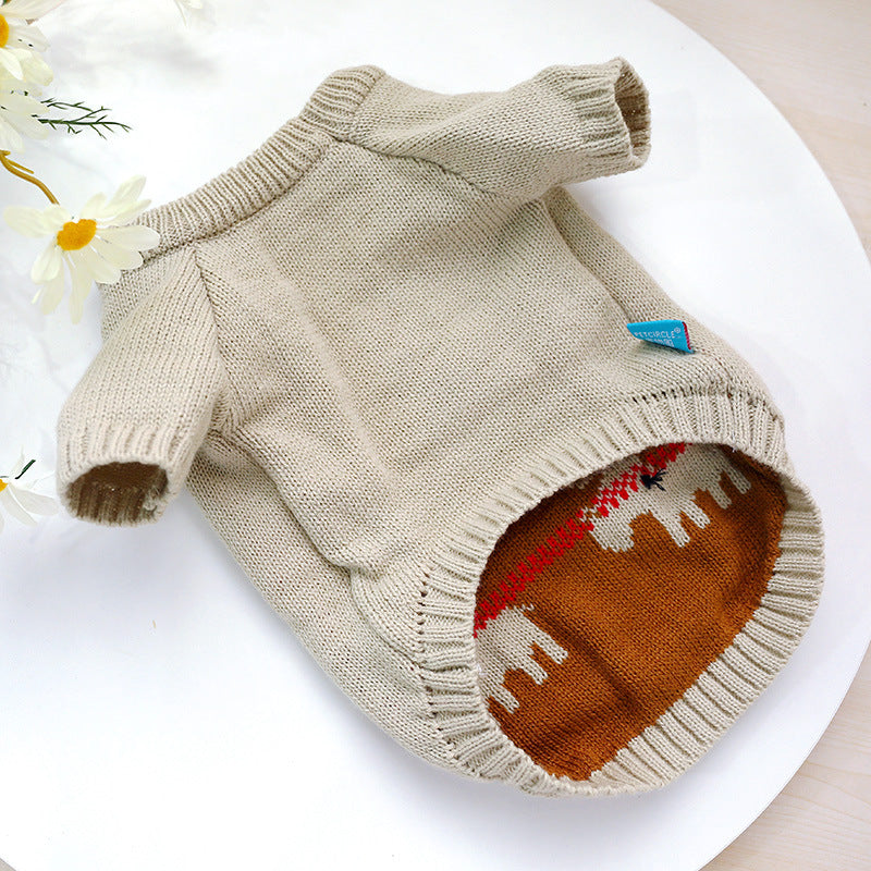 Knitted dog sweater with a colorful pattern on a white surface