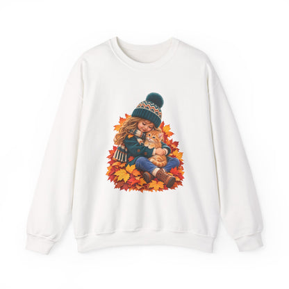 White crewneck sweatshirt featuring a little girl cuddling an orange tabby kitten among autumn leaves