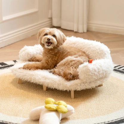 Dog lying on a fluffy white pet bed with a toy nearby.