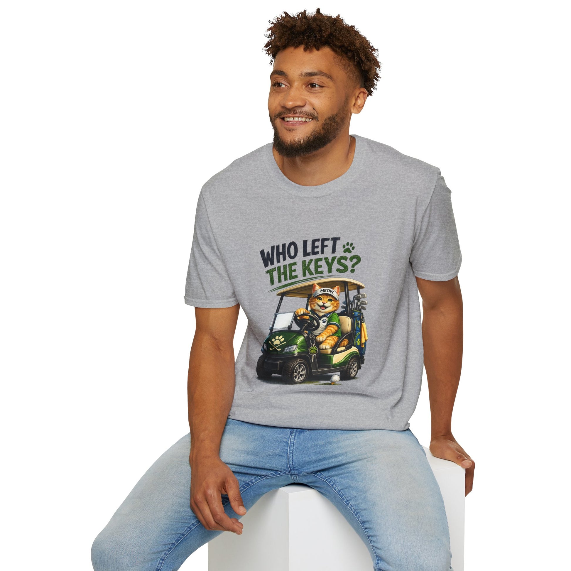 A heather gray short-sleeve crewneck t-shirt featuring a cartoon graphic of a cat driving a green golf cart with the text 'WHO LEFT THE KEYS?' printed on the chest.