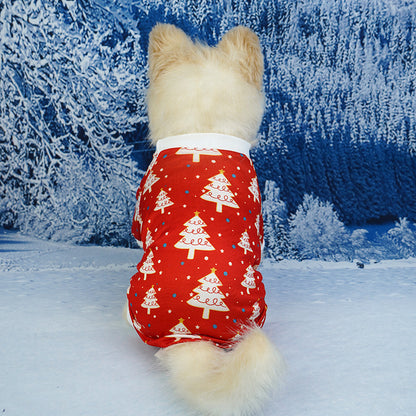 Dog wearing a red Christmas-themed outfit in a snowy landscape