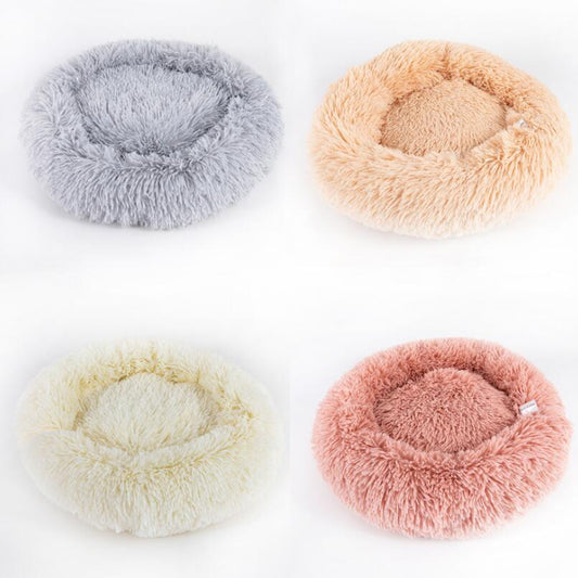 Four fluffy pet beds in different colors on a white background