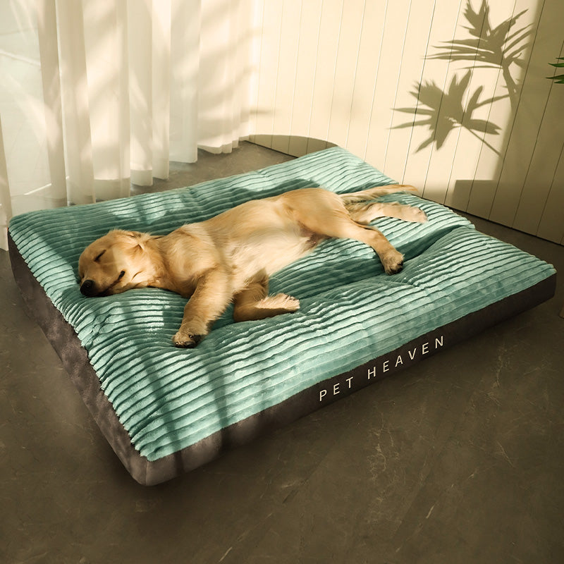 Dog sleeping on a green and gray 'Pet Heaven' bed indoors.