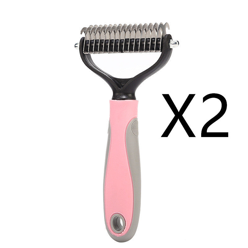 Pet grooming brush with pink handle and black bristles on a white background